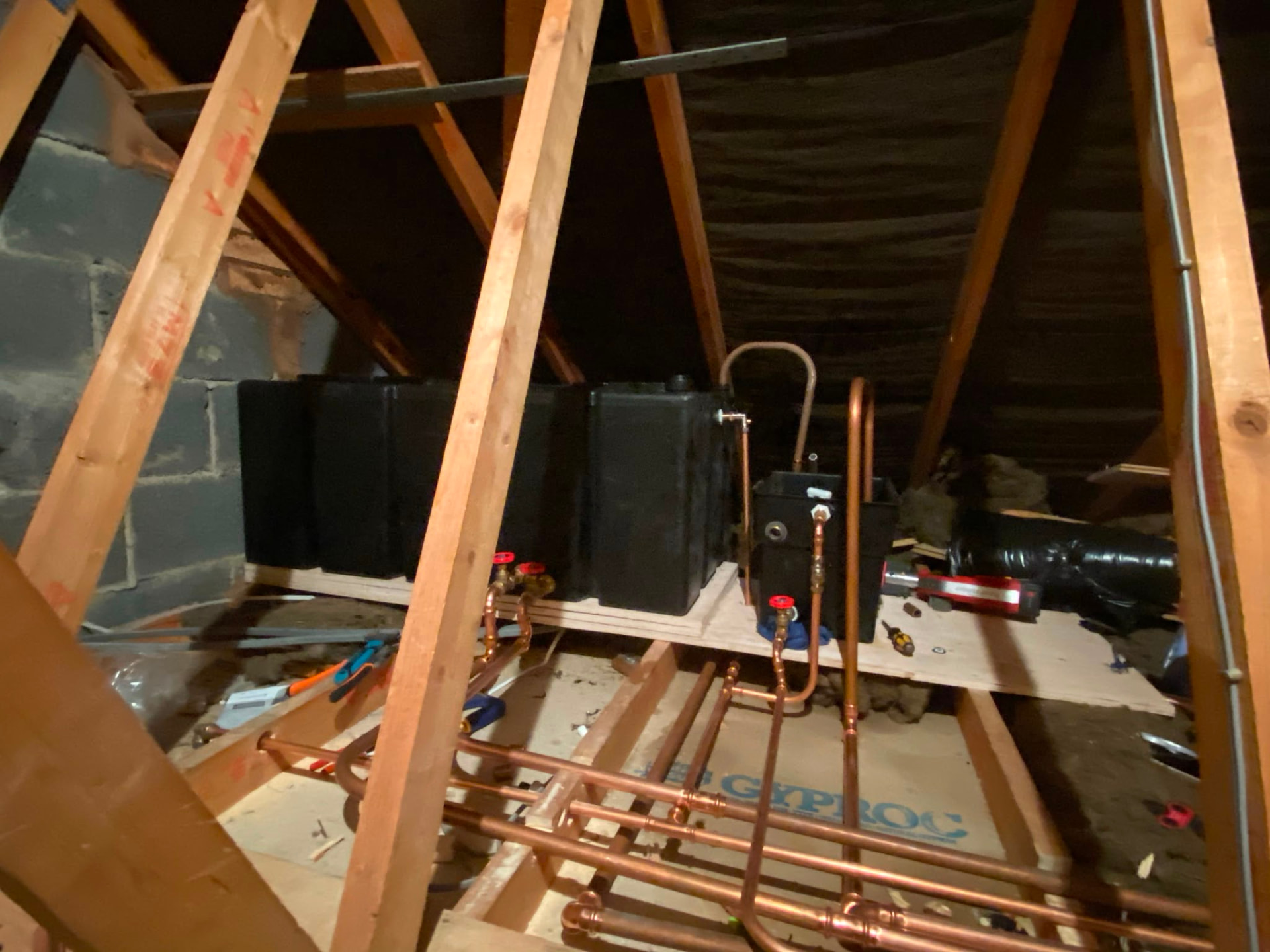 Loft cold water storage tank installation on timber boards with new copper pipework, fitted by Gas Safe registered engineers in Essex
